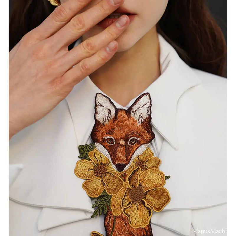 Embroidered tie of a fox playing with flowers