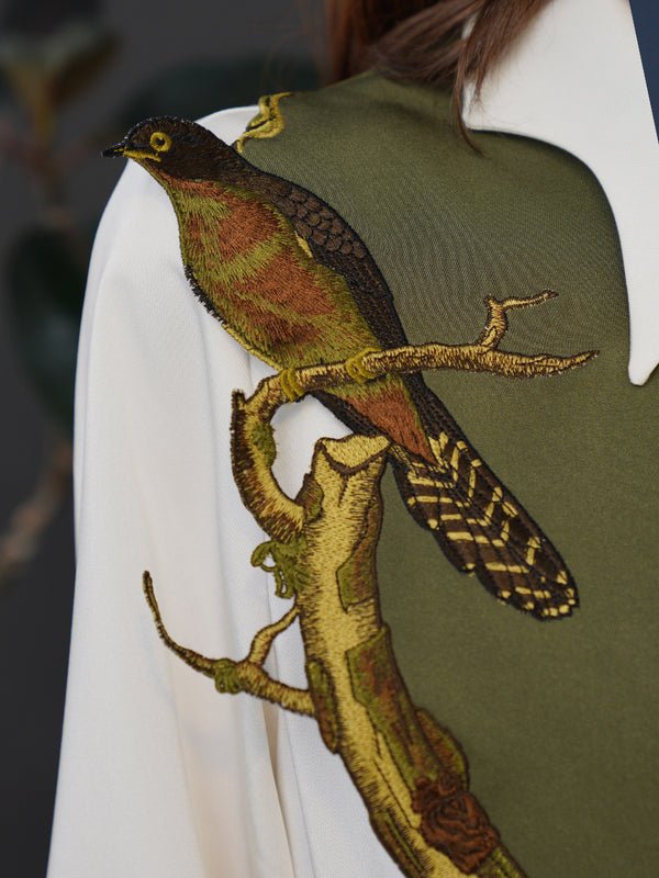 Embroidered bustier of a small bird perched on a branch