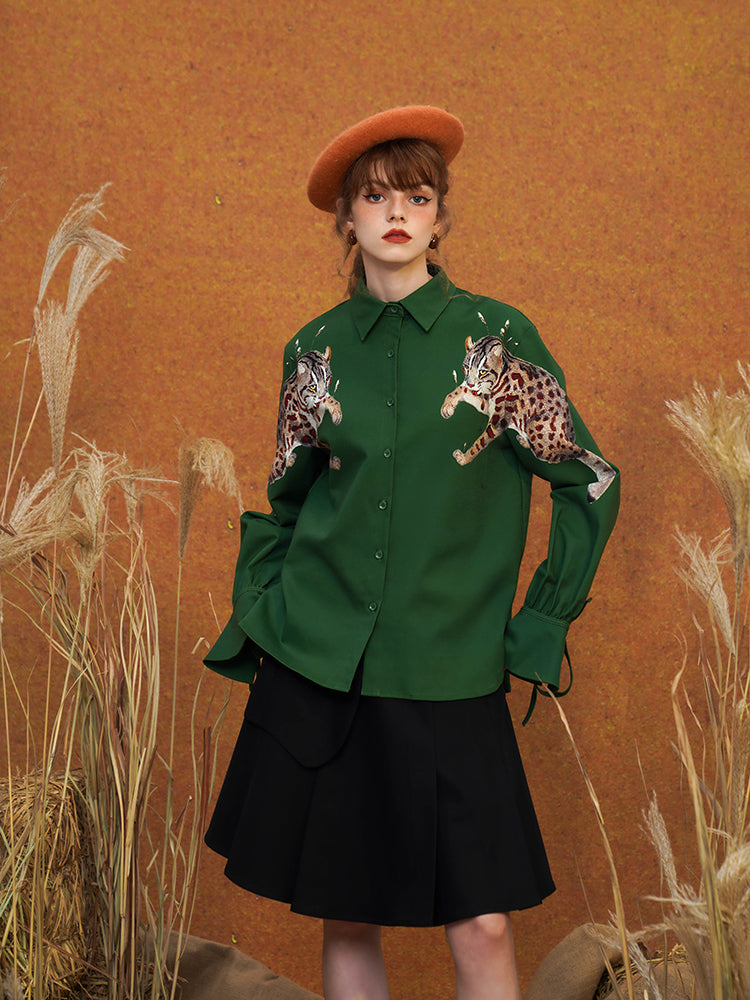 A blouse with a leopard wriggling in the shade of a leaf